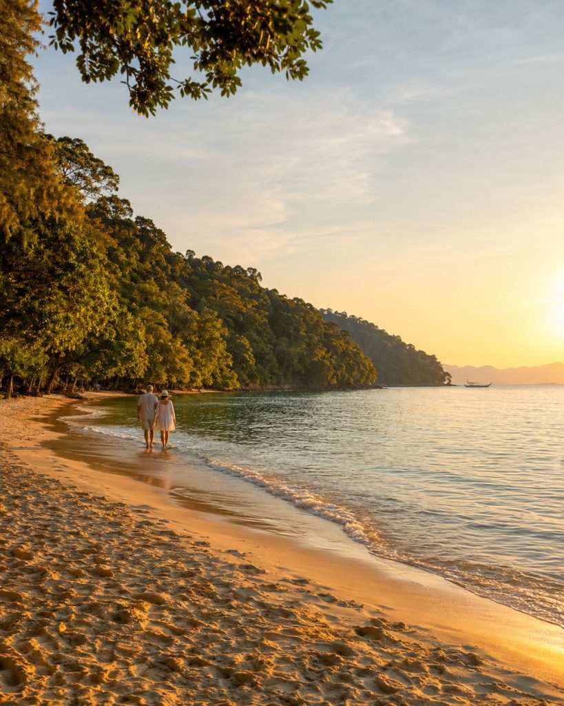 Penang coastline at golden hour, a couple walking the shoreline